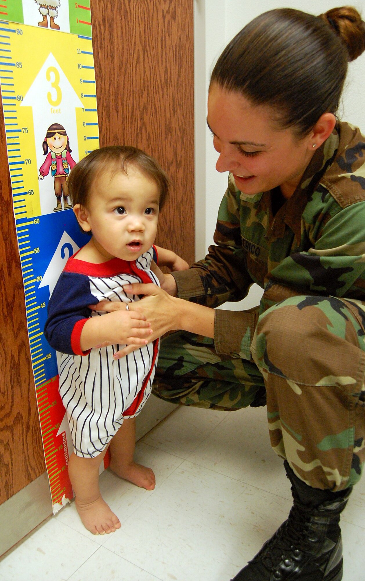 LAUGHLIN AIR FORCE BASE, Texas -- Airman Christina Alberico, 47th Medical Groups Pediatrics Technician, holds Nathan Pak, 1, son of Senior Airman Chae Pak, 47th Civil Engineering Squadron, and Stephanie Pak, next to a height chart made for small children during his one-year check up required by the 47th MG Pediatrics Clinic. (U.S. Air Force photo by Airman Sara Csurilla)