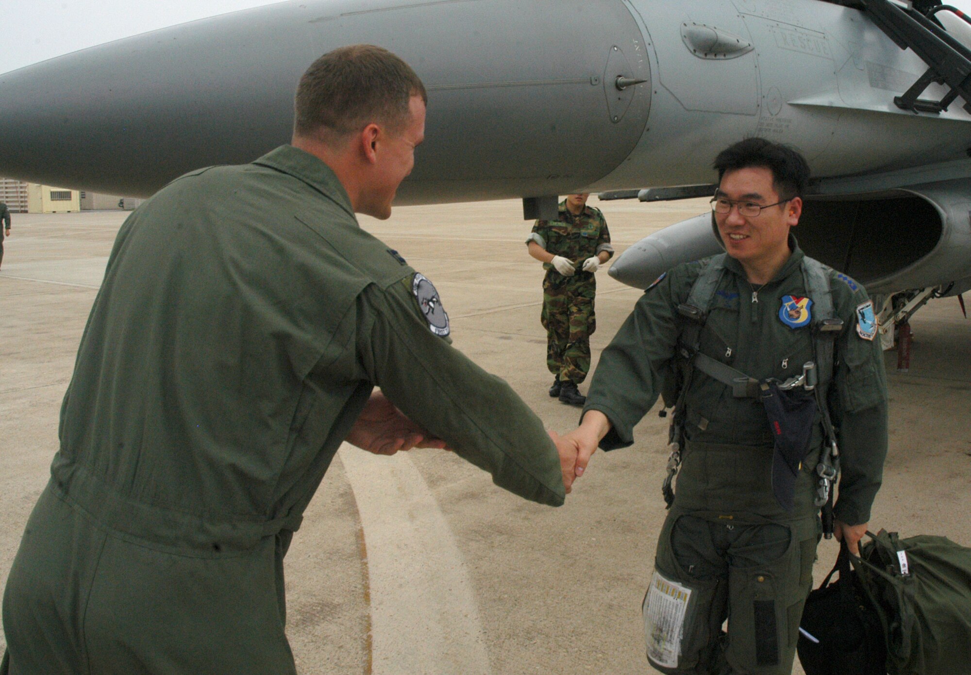 KUNSAN AIR BASE, Republic of Korea  June 27, 2007 -- Capt. Scott Johnson (left) greets Republic of Korea air force Capt. Yeon, Sang Mo during the 35th Fighter Squadron "Panton's" quarterly "Buddy Wing" program. The exchange program allows American and ROKAF pilots to learn about each other's flying operations to better operate in the event of hostilities on the peninsula. Captain Johnson is a pilot with the 35th FS. (U.S. Air Force photo/Senior Airman Stephen Collier)                                  