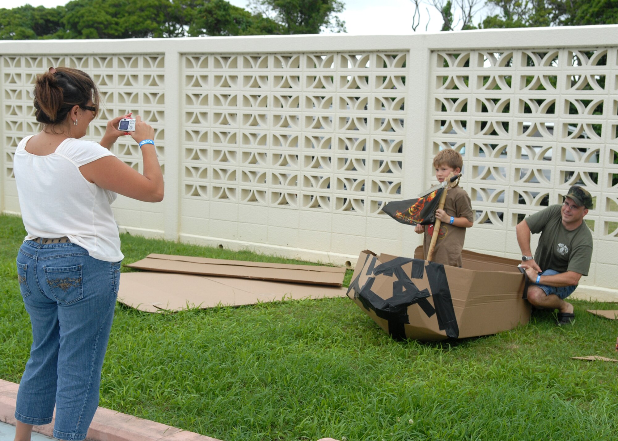 Beverly Champagne takes a picture of her son Josef and husband Master Sgt. Richard Champagne during the build-a-boat contest held June 16 at the hagstrom Pool on Kadena Air Base, Japan. More than 50 people divided among seven teams competed. Competitors were only supplied with a roll of duct tape, three large pieces of cardboard and a cutting knife.
U.S. Air Force photo/Senior Airman Jeremy McGuffin