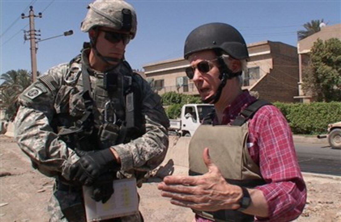 Capt. Josh Richardson (left), commander, Battery B, 2nd Battalion, 319th Airborne Field Artillery Regiment, listens to advice from U.S. Ambassador to Iraq Ryan Crocker while patrolling Richardson’s area of operations in the Raabi neighborhood of Baghdad’s Adhamiyah District, June 25. 

