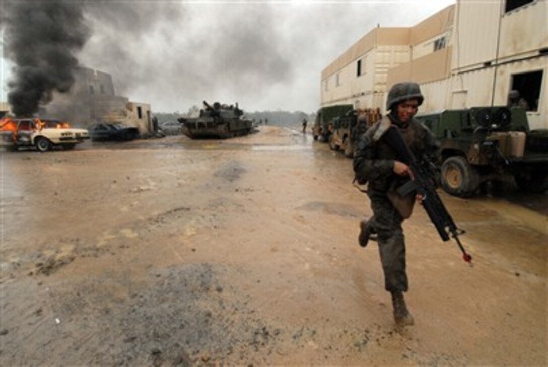 A U.S. Marine runs for cover while defending Camp Raspberry during exercise Talisman Sabre 2007 at the Shoalwater Bay Training Area in Australia on June 26, 2007. The biennial exercise is designed to train Australian and U.S. forces in planning and conducting combined task force operations, which will help improve combat readiness and interoperability.  The Marine is attached to the 3rd Marine Expeditionary Brigade.  