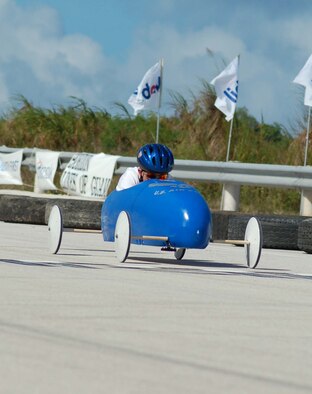 Jared with head down and leaning forward  as he is about to whiz past the finish line. The annual Guam soap box derby was held at the Yigo Racing Track. The soap box derby was sponsored by the Big Brothers/Sisters organization.