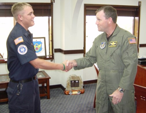 Brig. Gen. Douglas Owens, 36th Wing commander, presents William O’Meara with a coin from Michael Wynne, Secretary of the Air Force. O’Meara briefed Secretary Wynne on the fire station’s confined space program. (Courtesy photo)