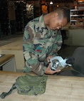 MINOT AIR FORCE BASE, N.D. -- Airman 1st Class Damian Dawkins, 5th Logistics Readiness Squadron, inspects a gas mask at the War Readiness Building here, also known as 777, before issuing it to an Airman June 28. Airmen are reminded as part of the upcoming July PHASE II exercise they will be evaluated on the proper wear and use of chemical gear. (U.S. Air Force photo by Airman 1st Class Wesley Wright)