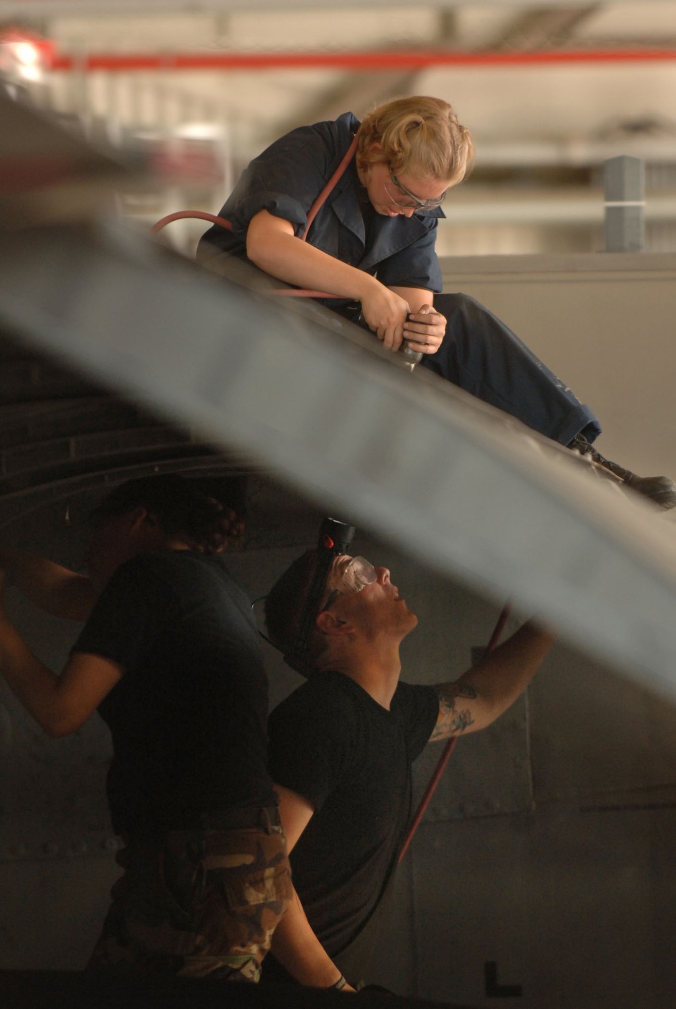 Staff Sergeants Anna Dunker and Steven Richardson install a sheet metal patch on the wing of a C-130 Hercules June 7 at Ramstein Air Base, Germany. The 47-year-old plane will soon represent the 86th Airlift Wing in the 2007 Air Mobility Command Rodeo at McChord Air Force Base, Wash. Both Airman assigned to the 86th Aircraft Maintenance Squadron. (U.S. Air Force photo/Master Sgt. Scott Wagers) 
