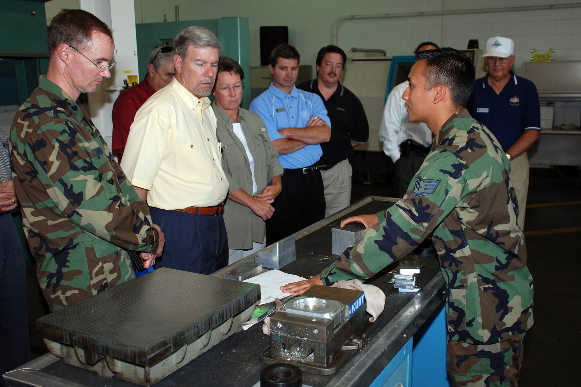 Staff Sgt. Julian Chavez, 22nd Maintenance Squadron, explains the process of turning raw metal into pieces of material needed for aircraft and shop repairs to honorary commanders during an orientation of the 22nd Maintenance Group June 20. The group experienced a day in the life of a McConnell “knucklebuster” by touring several different 22nd MXG workshops and touring a KC-135 Stratotanker. (Photo by Airman 1st Class Jessica Lockoski)