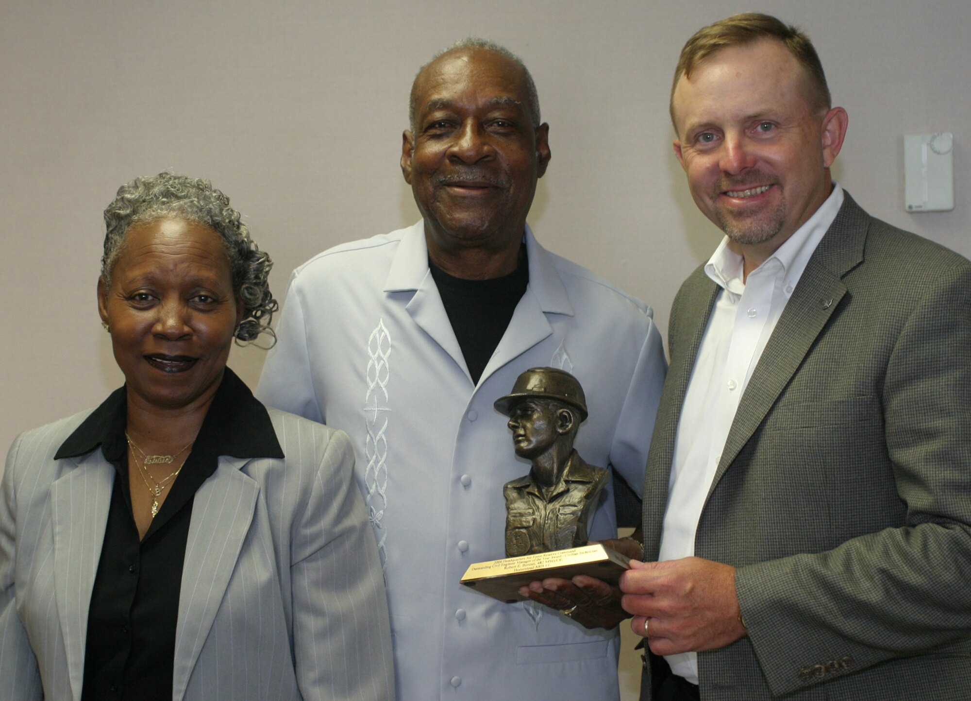Mr. Robert E. “Bobby” Bennett (center) stands with his wife Susie as he accepts an award from Mr. Scott Hastings, Deputy Civil Engineer for Air Force Reserve Command.  Mr. Bennett received the Civil Engineer Manager of the Year award for Air Force Reserve Command June 22.  Mr. Bennett plans to retire July 31 after serving 23 years at Homestead Air Reserve Base, Fla., as a carpenter insulator. (U.S. Air Force photo/Tech. Sgt. Paul Dean)
