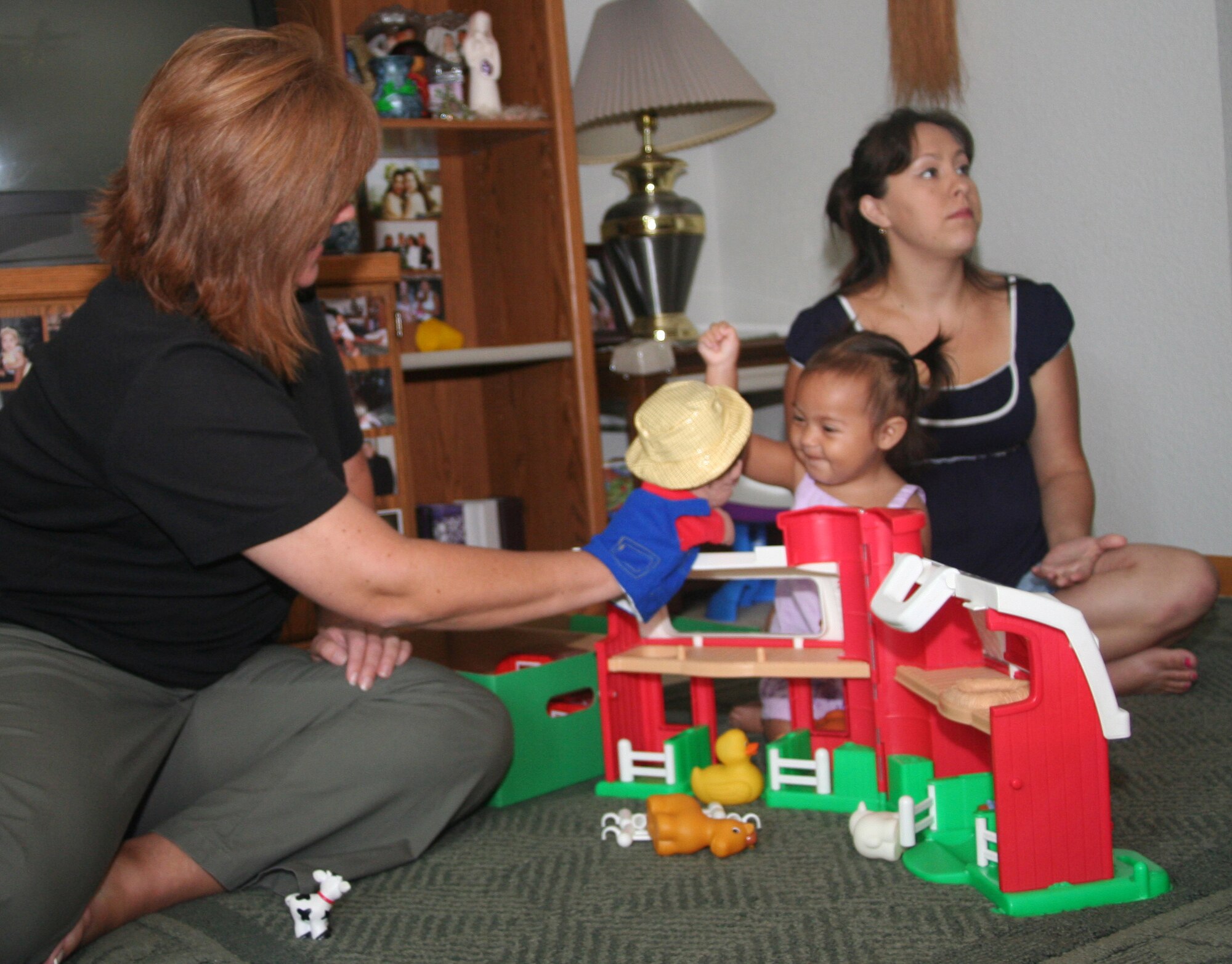 WHITEMAN AIR FORCE BASE, Mo. -- Dawn McCoy, Parents as Teachers parent educator, (left) uses a hand puppet to play with Azucena Baclayon, daughter of Zela (far right) and Staff Sgt. Kaola Baclayon, 509th Maintenance Squadron. (U.S. Air Force photo/Tech. Sgt. Matt Summers)