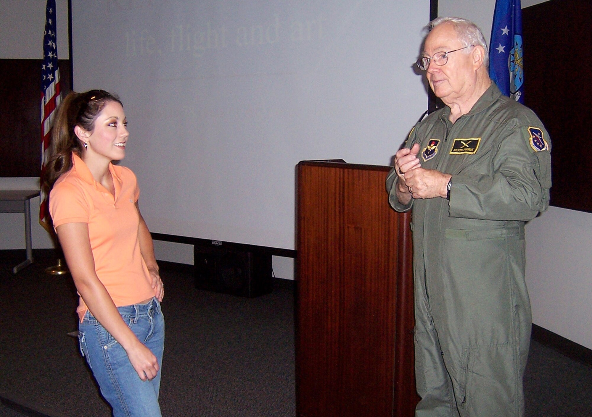 Mr. Keith Ferris, Air Force aviation artist, discusses his art techniques with Jana Hudson, wife of Capt. Dustin Hudson, 37th Flying Training Squadron Instructor Pilot, Thursday during a briefing in the Phillips Auditorium. (U.S. Air Force Photo by Sonic Johnson)