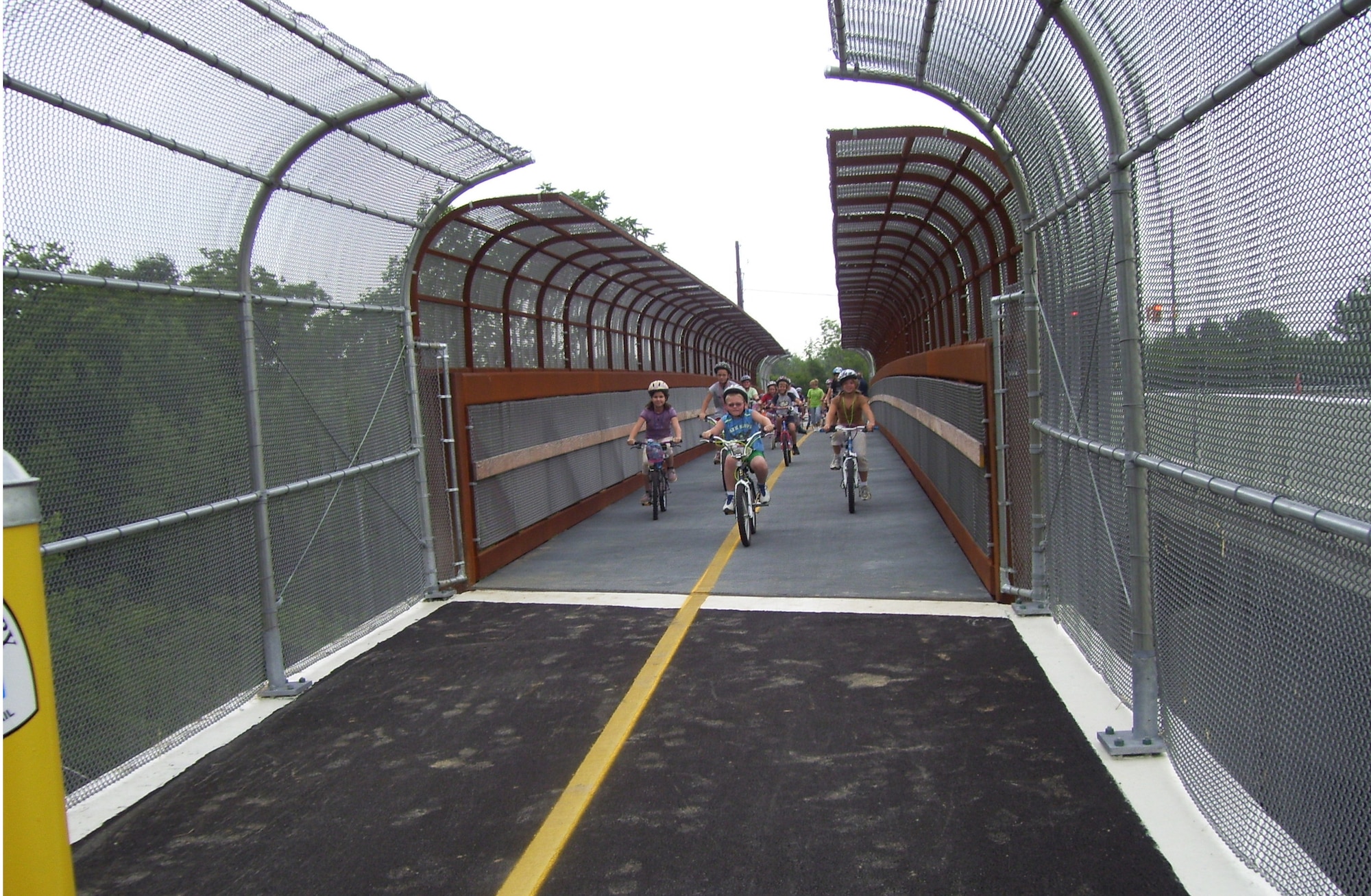 Children from the Greene County Summer Caravan program make the inaugural ride over the new T-Connector Trail bridge.  The bridge links the entrance to the Huffman Prairie Flying Field Interpretive Center at Wright-Patterson Air Force Base, near State Route 444 in Fairborn, Ohio to other Greene and Montgomery County bikeway trail systems in the Miami Valley area.  The bridge deck was constructed with advanced composite materials originally developed by Air Force Research Laboratory scientists for aircraft. (Greene County Parks Photo)