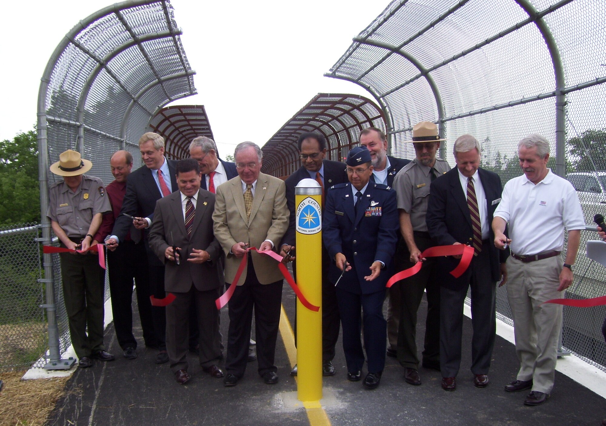 Col. Jay Strickler, 88th Air Base Wing vice commander, joins with Congressman David Hobson, Greene County Park District Commissioner John Finlay, Greene County Commissioners Rick Perales and Alan Anderson, members of the National Park Service and others in the dedication of the new T-Connector Trail bridge.  The bridge links the entrance to the Huffman Prairie Flying Field Interpretive Center at Wright-Patterson Air Force Base, near State Route 444 in Fairborn, Ohio to other Greene and Montgomery County bikeway trail systems in the Miami Valley area.  The bridge deck was constructed with advanced composite materials originally developed by Air Force Research Laboratory scientists for aircraft. (Photo by Greene County Parks)