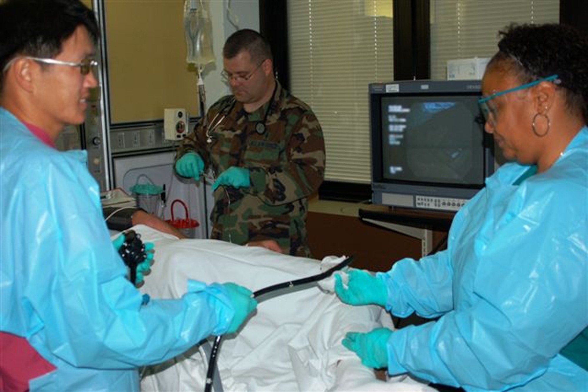 Major Kang, left, prepares to perform a colonoscopy procedure in his clinic’s current procedure room in the medical center’s intensive care unit.  He’s assisted by Captain Anshutz and Ms. Dawson.  (U. S. Air Force photo by Steve Pivnick)