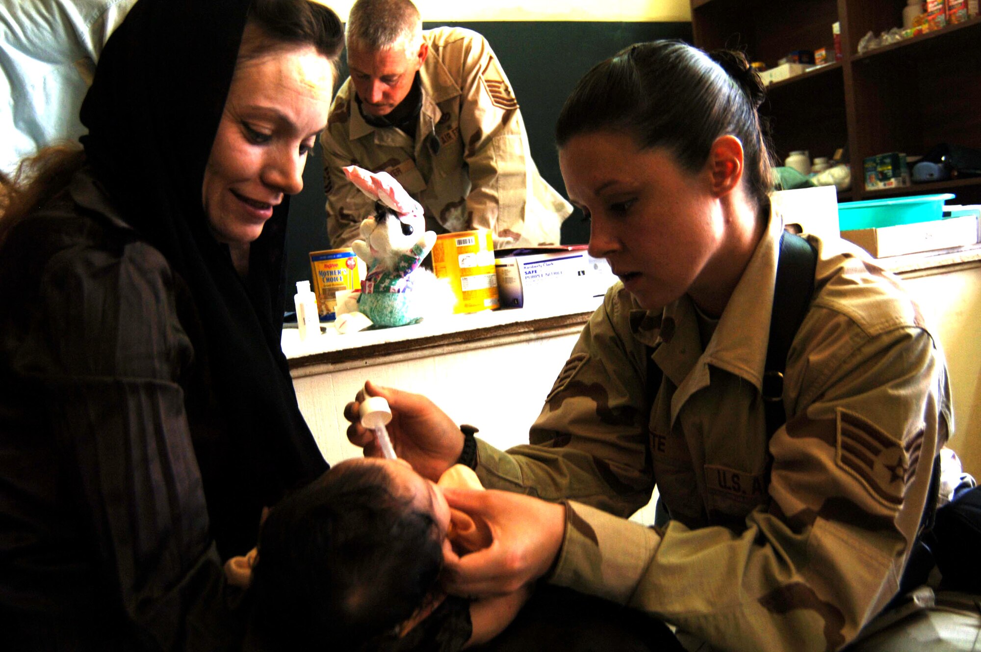 Staff Sgt. Kelly Jette (right) applies medication to the nose of an Iraqi infant June 21 at the Civil-Military Operations Center medical clinic at Camp Striker, Iraq. Sergeant Jette is assigned to the 447th Expeditionary Medical Squadron. The Civil-Military Operations Center medical clinic provides free medical service to impoverished Iraqi citizens. (U.S. Air Force photo/Tech. Sgt. Russell Wicke)

