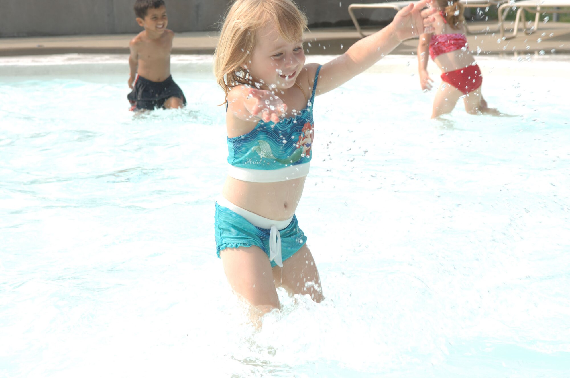 LANGLEY AIR FORCE BASE, Va. -- Anna Robinson, daughter of Amy Robinson, 1st Fighter Wing Public Affairs, splashes around at the Shellbank kiddie pool June 26. Throughout the summer, children at the Russ Child Development Center take a number of field trips around Langley including walks to the bowling center, library, pool, arts and crafts center and Eagle Park. (U.S. Air Force Photo/Senior Airman Tabitha Kuykendall)