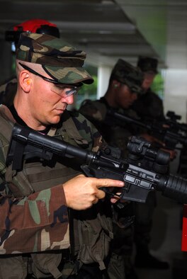 Tech. Sgt. Matt Howard, Senior Airman Dustin Burk, and Airman 1st Class Schermund Smith, 18th Security Forces Squadron, check their weapons before firing drills prepared by a combat arms Instructor.  Live firing drills and scenarios are just one of many training events these Kadena Air Base, Japan, Airmen are going through to prepare for the Air Mobility Rodeo 2007. More than 40 teams and 2,500 people from the Air Force, the Air Force Reserve, and allied nations, will compete in the AMC Rodeo at McChord AFB, Wash., in July.  The readiness competition focuses on worldwide air mobility capabilities.
U.S. Air Force photo/Senior Airman Jeremy McGuffin