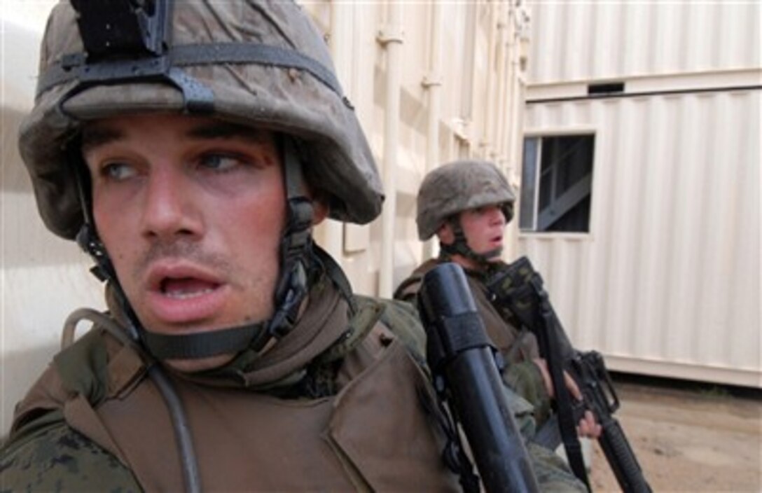 A U.S. Marine from the 3rd Marine Expeditionary Brigade peers around the corner of a building while defending Camp Raspberry from Australian army soldiers during Exercise Talisman Sabre 2007 at the Shoalwater Bay Training Area in Queensland, Australia, on June 26, 2007.  Camp Raspberry is a simulated city used to train service members how to operate in an urban environment.  The biennial exercise is designed to train Australian and U.S. forces in planning and conducting combined task force operations that help improve combat readiness and interoperability.  