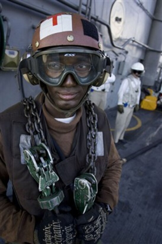 U.S. Navy Aviation Machinist's Mate Airman Franco Gilbert waits to chain down an aircraft aboard the USS Kitty Hawk (CV 63) on June 25, 2007.  The Kitty Hawk is underway in the Coral Sea participating in Exercise Talisman Sabre 2007.  The biennial exercise is designed to train Australian and U.S. forces in planning and conducting combined task force operations that help improve combat readiness and interoperability.  