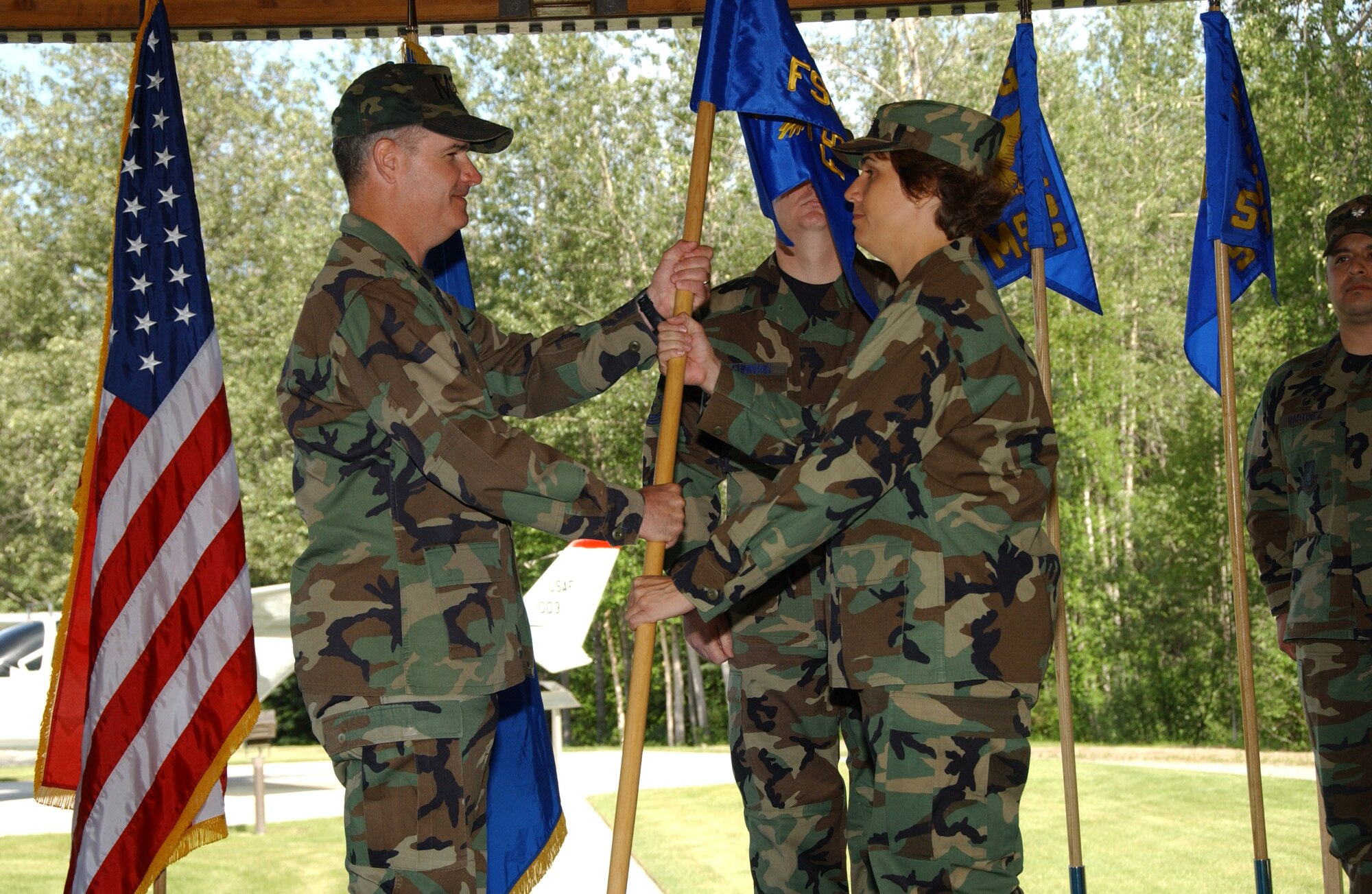 EIELSON AIR FORCE BASE, Alaska -- Maj. Catherine McGowan, 354th Force Support Squadron commander, accepts the squadron flag from Col. James Martin June 27 here. There are currently only six bases under structure of merging their Mission Support Squadrons and Services Squadrons into a Force Support Squadron; Eielson being the only one in the Pacific Air Forces and the first to hold a change of command ceremony for this squadron.  (U.S. Air Force photo by Airman 1st Class Christopher Griffin)