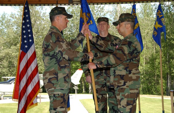 EIELSON AIR FORCE BASE, Alaska -- Lt. Col. John Martinez, 354th Force Support Squadron commander, hands Col. James Martin, 354th Mission Support Group commander, the squadron flag during a change of command ceremony June 27 here. There are currently only six bases under structure of merging their Mission Support Squadrons and Services Squadrons into a Force Support Squadron; Eielson is the only one in Pacific Air Forces and is also the first to hold a change of command ceremony for this squadron. (U.S. Air Force photo by Airman 1st Class Christopher Griffin)