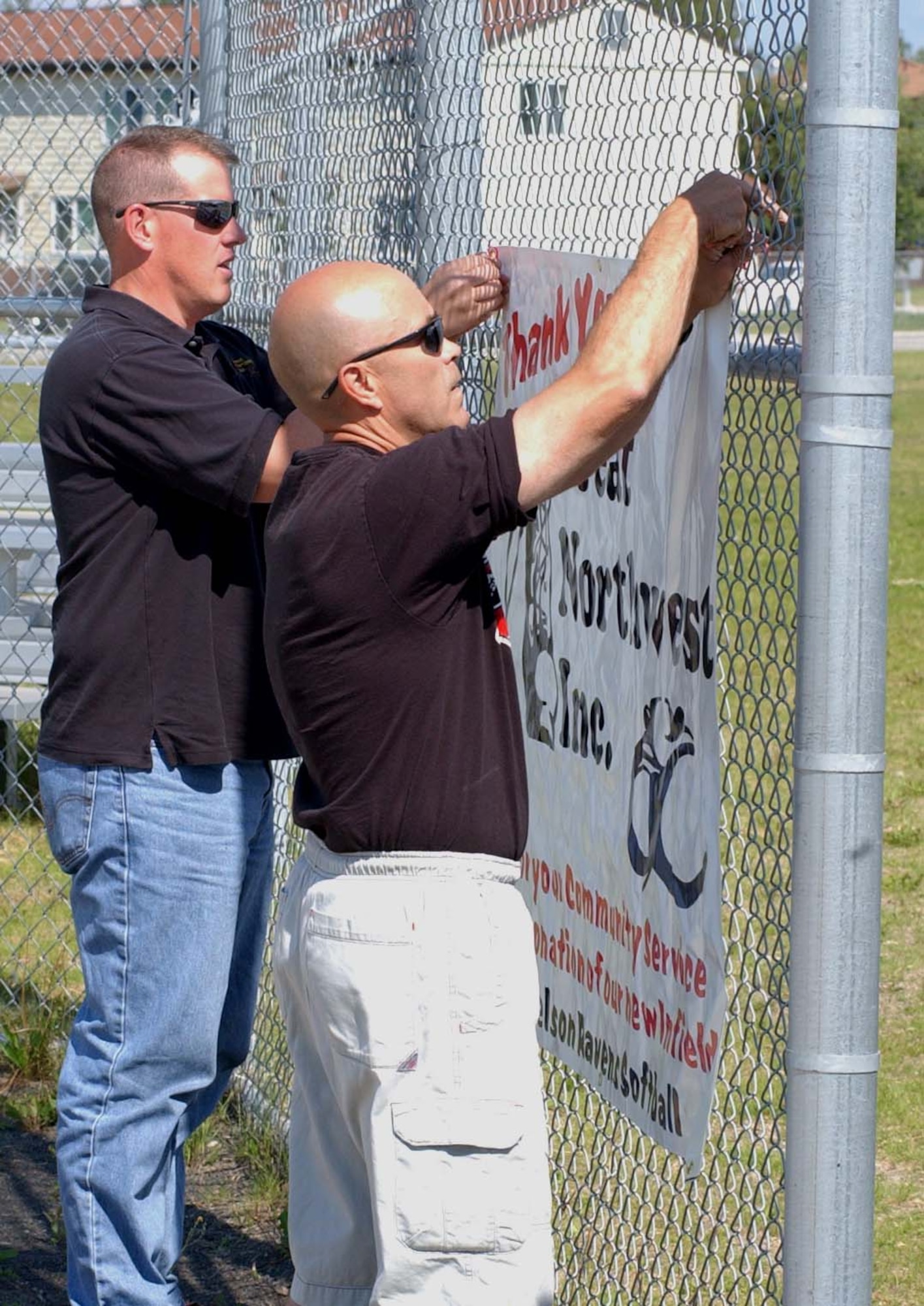 EIELSON AIR FORCE BASE, Alaska--Jim Young (left) and Raven's Coach Shane McAfee hang a thank you sign at the Ben Eielson Softball Field June 29. Jim Young and Great Northwest Inc., along with Ben Lomond Inc. donated more than $10,000 worth of time and material to upgrade the girl's softball field. Coach McAfee solicited the help of the local community to aid in the renovation of the field. (U.S. Air Force photo by Senior Airman Justin Weaver)