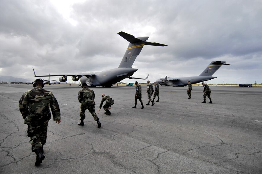 HICKAM AIR FORCE BASE, Hawaii -- Crew chiefs conduct a foreign object debris (FOD) walk June 28 before launching a C-17 Globemaster III. The Airmen, from the 15th Aircraft Maintenance Squadron, are practicing for the upcoming Air Mobility Command Rodeo at McChord Air Force Base, Wash. (U.S. Air Force photo/ Tech. Sgt. Shane A. Cuomo)