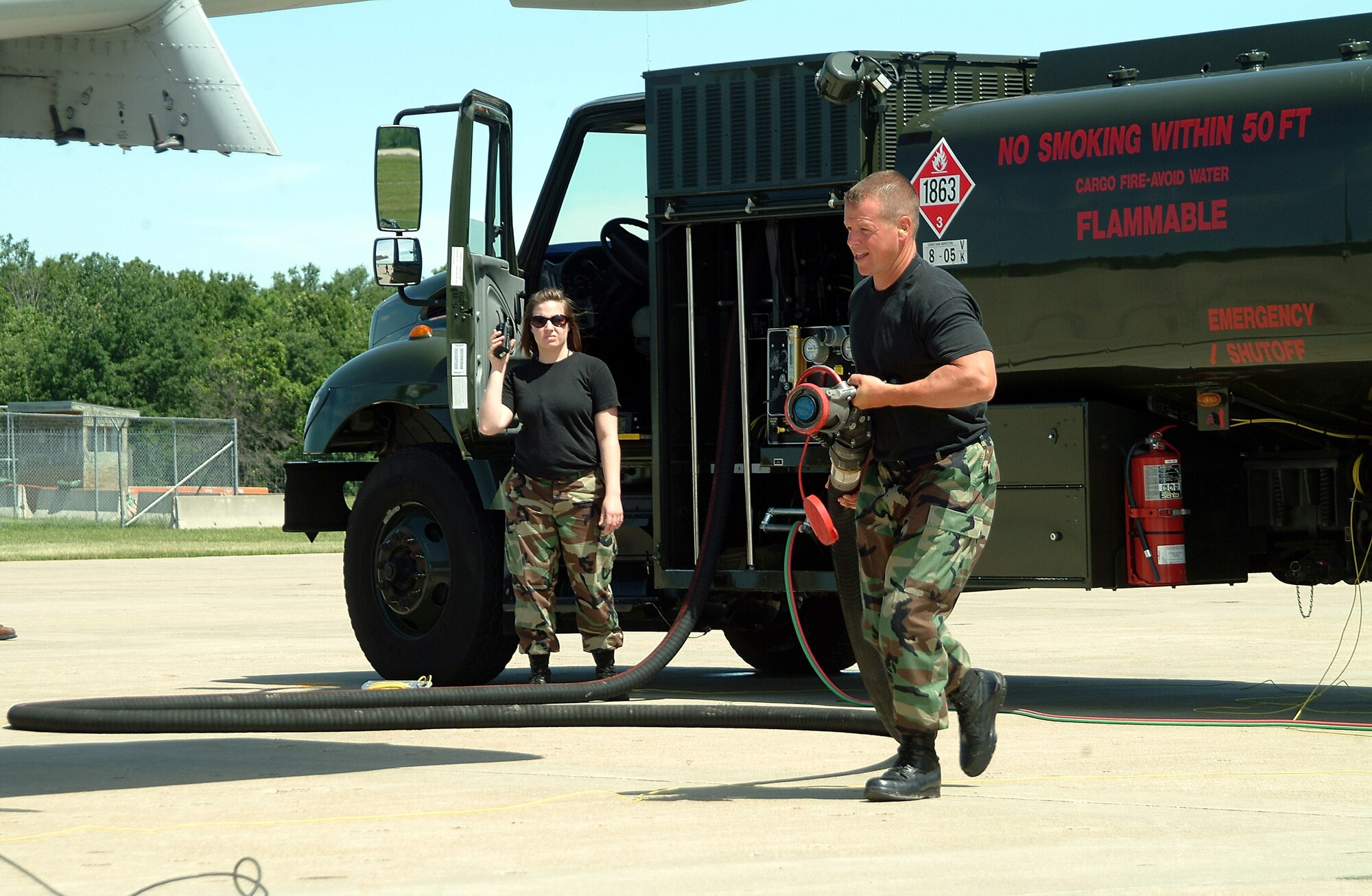 Under the watchful eye of  Senior Airman Charlotte Allen, Senior Master Sgt.  James Hamby drags a refueling hose to a waiting A-10 Thunderbolt II during a hot-pit refueling  on Whiteman AFB, Mo.'s ramp. The two 442nd Logistics Readiness Squadron reservists assigned to the 442nd Fighter Wing,  helped service eight A-10's as the aircraft landed, refueled and took off again during an exercise designed to enable pilots to quickly return to the fight. (U.S. Air Force photo/Master Sgt. Bill Huntington)