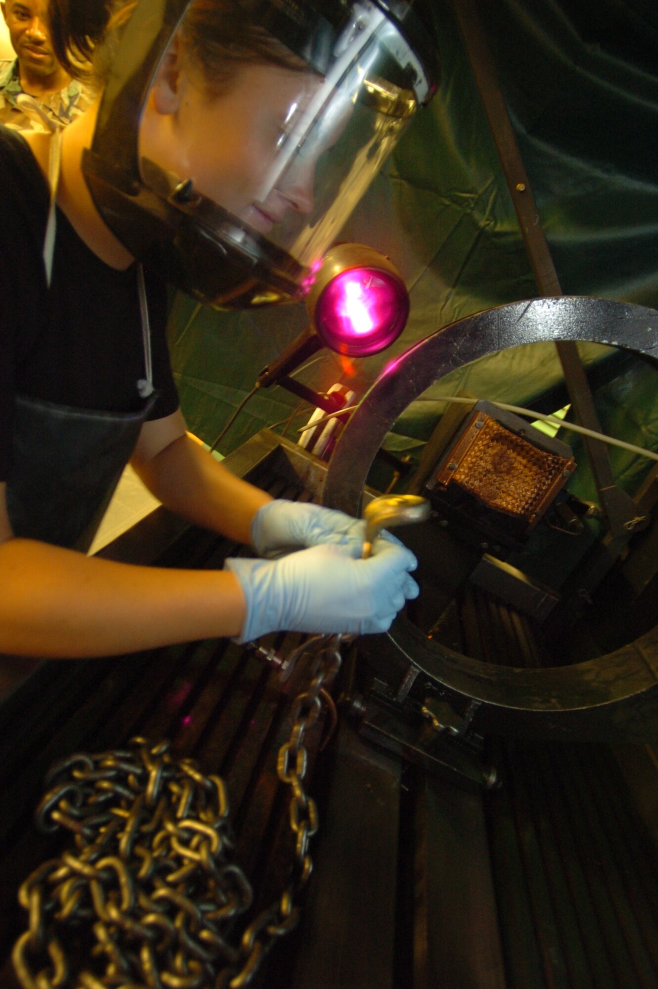 Airman 1st Class Kasey Hoyem inspects a part for weakness and cracks using UV technology at Hickam Air Force Base, Hawaii. Airman Hoyem is assigned to the 15th Maintenance Squadron. (U.S. Air Force photo/Angela Elbern)