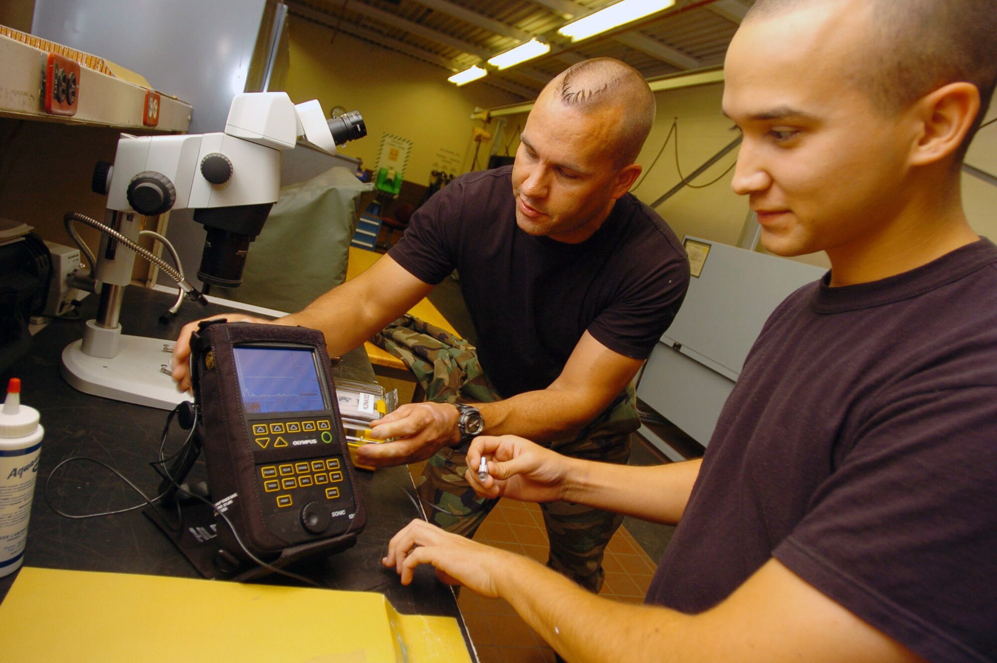 Airman 1st Class James Watts and Tech. Sgt. Stan Rothfuss inspect an airplane part for cracks and damage at Hickam Air Force Base, Hawaii. They are using sonogram technology to detect damage to the composite material that makes up a C-17 Globemaster III. Airman Watts is nondestructive inspection lab inspector at the 15th Maintenance Squadron, and Sergeant Rothfuss is a reservist from McChord Air Force Base, Wash. (U.S. Air Force photo/Angela Elbern)
