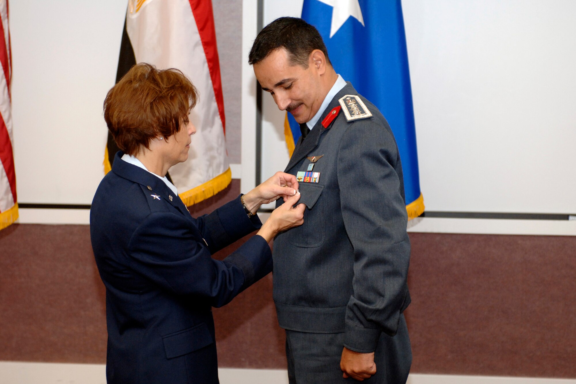 Brig. Gen. Kathleen Close, Ogden Air Logistics Center commander, pins a symbolic star on the pocket of recent promotee Brig. Gen. Hesham Ahmed, Egyptian Air Force international liaison officer, June 28. General Ahmed's duties on Hill Air Force Base include the management of EAF F-16 Fighting Falcons and F-4 Phantoms. (U.S. Air Force photo by Alex R. Lloyd)