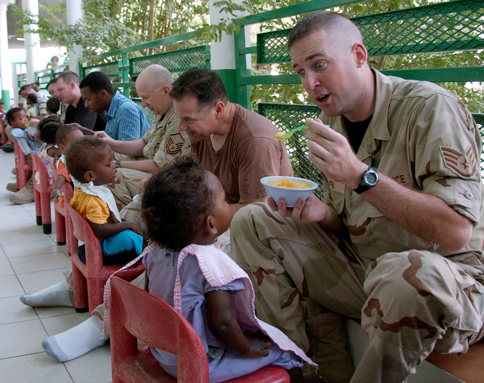 Staff Sgt. Joe Filipek and other members of the U.S. Central Air Forces expeditionary band "Thunder Roll" feed infants during a visit to an orphanage near Camp Lemonier, Djibouti. The band was visiting the area for a five-day concert tour. (U.S. Air Force photo/Staff Sgt. Samuel King Jr.)
