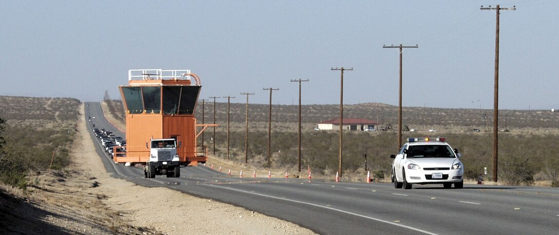 A truck carries the cab of the old Air Force Flight Test Center control tower down Rosamond Boulevard on June 21. The cab will be the centerpiece of the Century Circle display, which is outside the West Gate. The AFFTC museum has been restoring the 18-foot high, 28-foot wide cab since November 1988 when the old tower was demolished following construction of the existing tower. Six Century Series aircraft, the F-100, F-101, F-102, F-104, F-105 and F-106, will join the tower on the display site. (Photo by Doug Nelson)