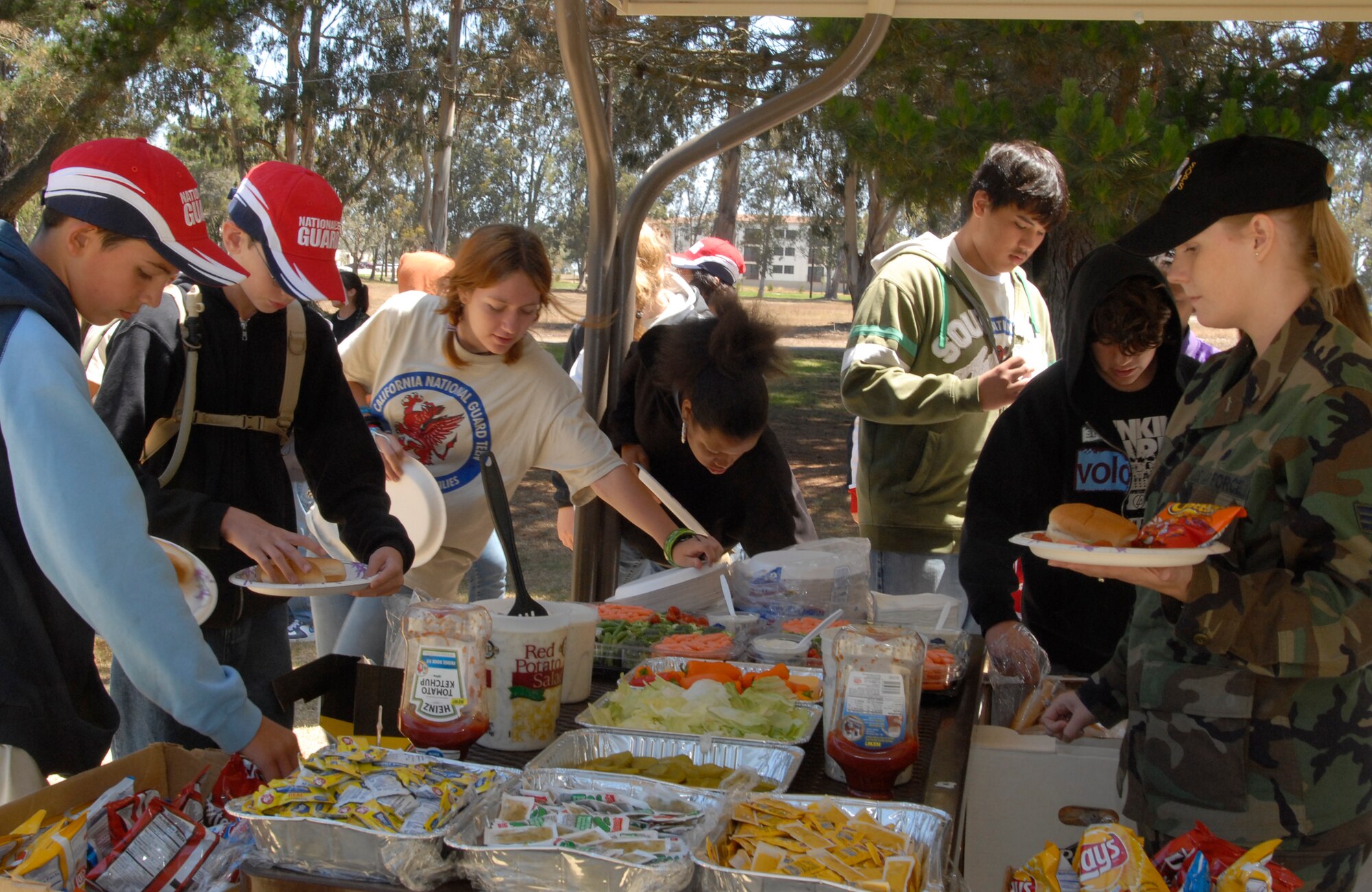 VANDENBERG AIR FORCE BASE, Calif. --  Junior Reserve Officer Training Corps students and dependents of Air and Army National Guard stationed out of Fresno, Calif., have a luncheon at Cocheo Park on June 25.  Senior Airman Melissa Conklin (right) of the 148th Space Operations Squadron, escorts a group of over a 101 school children of various ages to show them the occupational impact and lifestyle demands of their parents, many of whom live nowhere near a military installation. (U.S. Air Force photo/Senior Airman Kristi Emler)