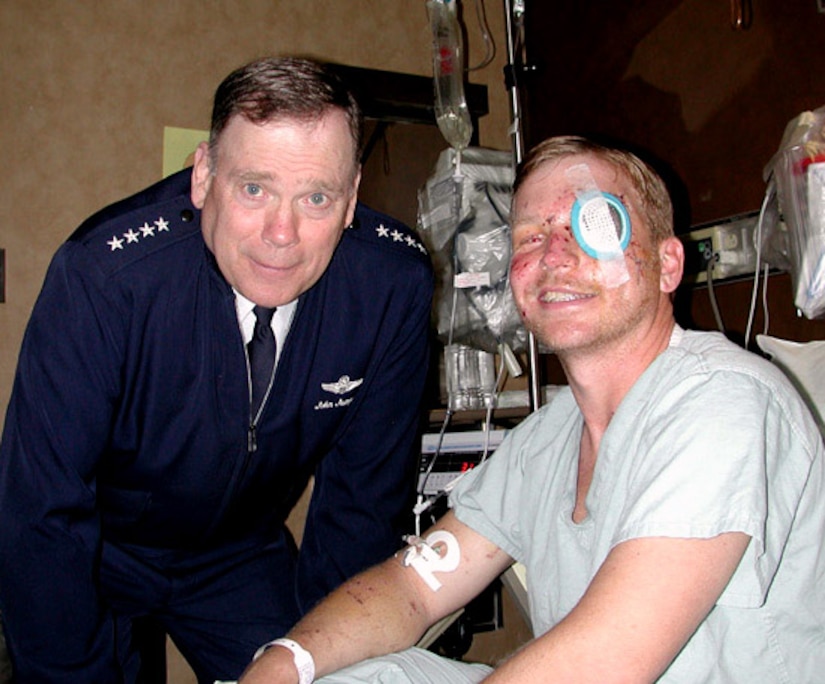 Then-Air Force Chief of Staff Gen. John Jumper visits Tech. Sgt. Christian MacKenzie at Wilford Hall Medical Center in 2004 at Lackland Air Force Base, Texas. Sergeant MacKenzie, who served as a special operations MH-53 Pave Low flight engineer, was shot down April 13, 2004, in Fallujah, Iraq. (U.S. Air Force photo) 
