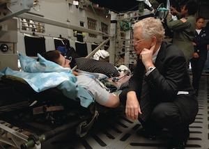 Dr, Samuel W. Casscells, Assistant Secretary of Defense for Health Affairs, speaks to an injured soldier who recently returned from overseas. The Secretary visited the Malcolm Grow Medical Center's Aeromedical Staging Flight Tuesday.