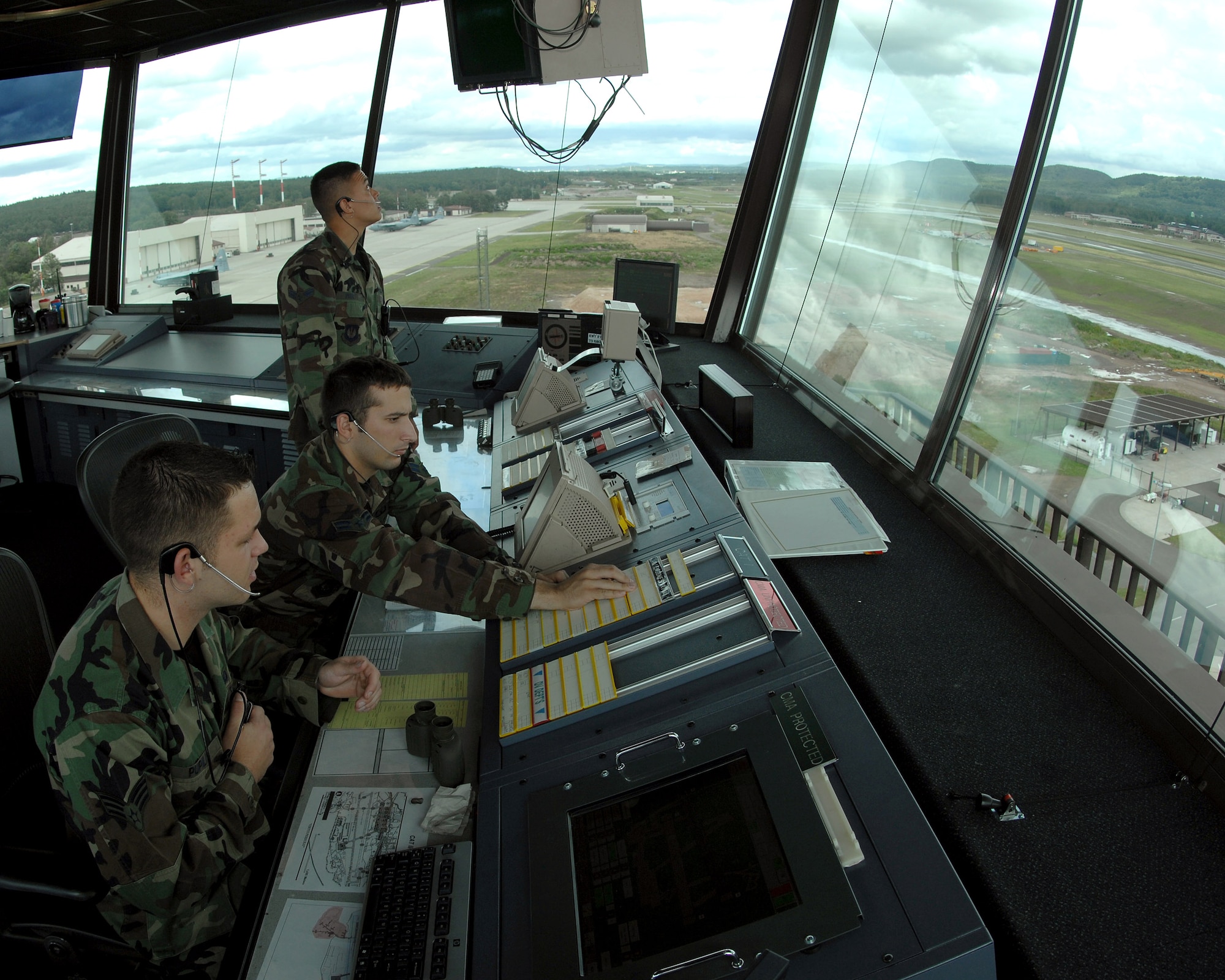 Senior Airman Robert Pupilis (left to right), Airman 1st Class Toby Jacob and Airman 1st Class Earl Pruett work ensure all inbound and outbound aircraft arrive and depart safely June 26 from the control tower at Ramstein Air Base, Germany. The Airmen are assigned to the 86th Operations Support Squadron. (U.S. Air Force photo/Airman 1st Class Kenny Holston)
