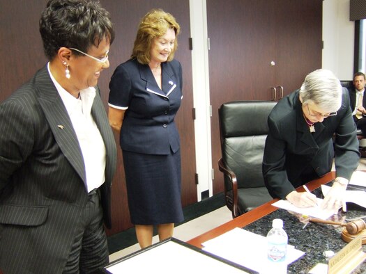 Columbus Regional Airports Authority Board of Directors Chairwoman Kathleen H. Ransier (left) and Air Force Real Property Agency Director Katie Halvorson (center) watch as CRAA President and Chief Executive Officer Elaine Roberts signs the deed for the final parcel of property at the former Rickenbacker Air National Guard Base, Ohio June 26. (Photo courtesy of the Columbus Regional Airports Authority)