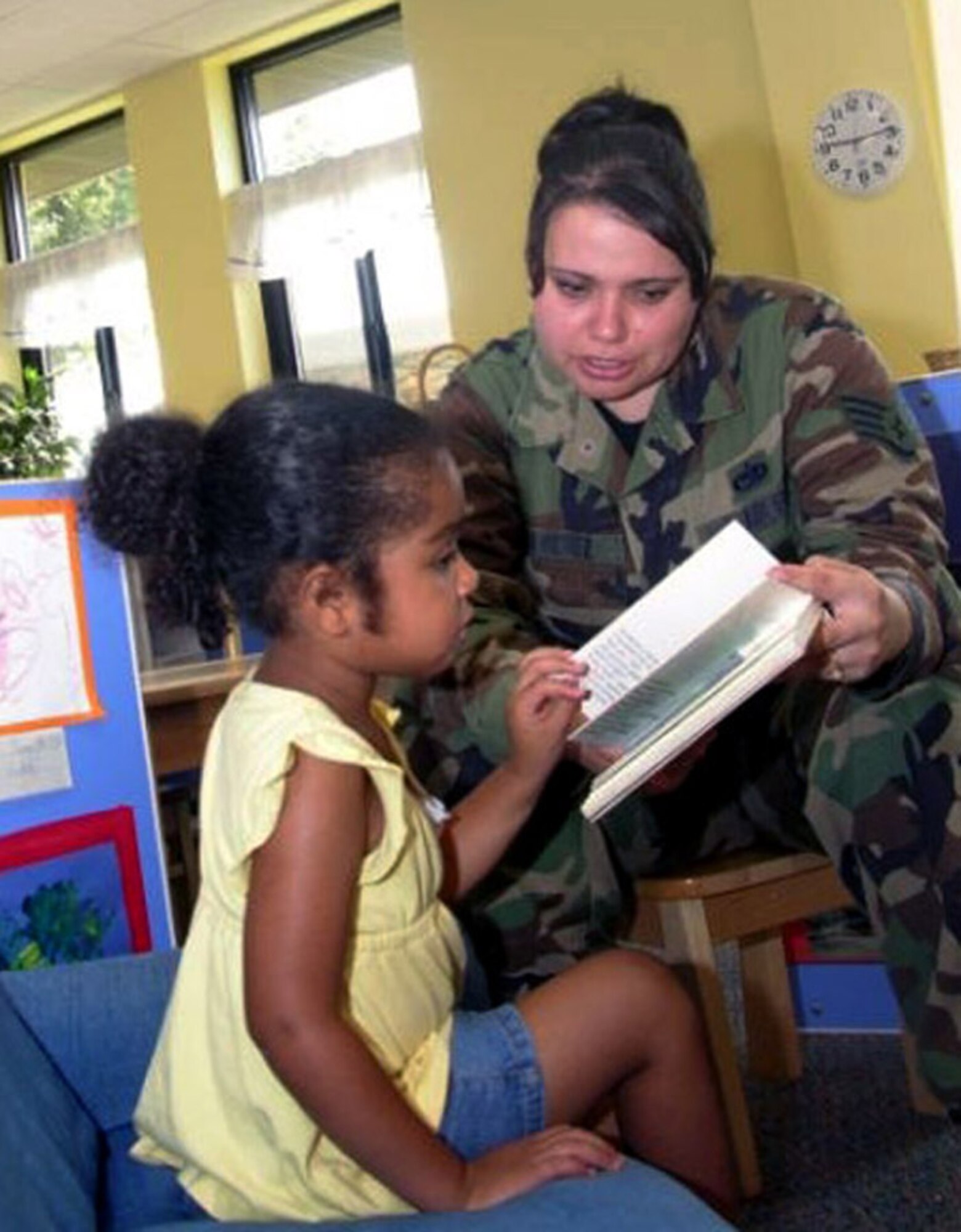 Staff Sgt. Tanya Sanchez, 1st Speical Operations Helicopter Maintenance Squadron, reads to her daughter Wednesday in the new annex. (U.S. Air Force photo by Jon Ortiz)