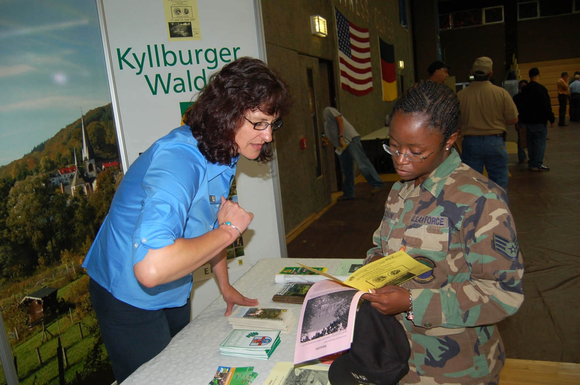 SPANGDAHLEM AIR BASE, Germany -- Staff Sgt. Charron Jackson, 52nd Maintenance Operations Squadron, talks to a representative from the Touristinfo Kyllburger Waldeifel about upcoming events. For more information about Kyllurger Waldeifel, call 06563-93-0243. (US Air Force photo/Iris Reiff)
