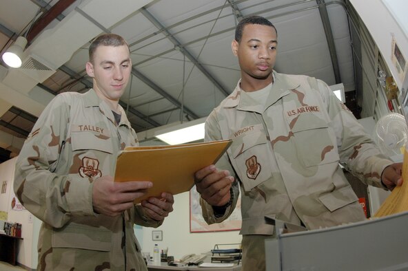 Airman 1st Class Scott Talley (left) and Senior Airman Sadarius Wright (right), both with 379th Expeditionary Services Squadron PERSCO team, review personal infomration files for accuracy. The PERSCO team here is responsible for transitioning any Airmen, Soldier, Sailor, Marine or coalition serviceman coming into or out of the Operation Iraqi Freedom theater, including any wounded personnel. (U.S. Air Force photo by Senior Airman Clark Staehle)