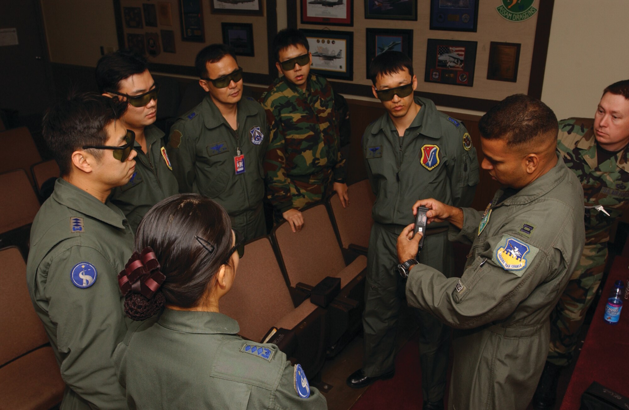 OSAN AIR BASE, Republic of Korea --  Capt. Andre Cardoza, 25th Fighter Squadron (far right), teaches pilots of the Republic of Korea Air Force, from the left: Capt. Pyoum, Capt. Suk, Capt. Chow, Maj. Som, 2nd Lt. Cho, Capt. Lee, about the use of the GCP-1C Ground Command Pointer and Panoramic Night Vision goggles during the Buddy Wing exercise here Dec. 5. (U.S. Air Force photo by Airman Jason Epley)