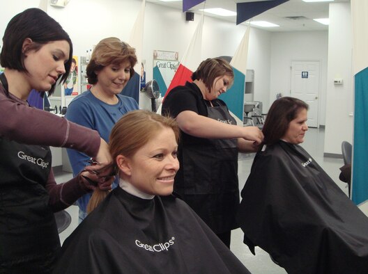 Tamera Wass and Kathy Blake, get their long hair transformed into short hair to donate it to Locks of Love and support their friend Tammy Smith (center) who recently won a battle with cancer.  