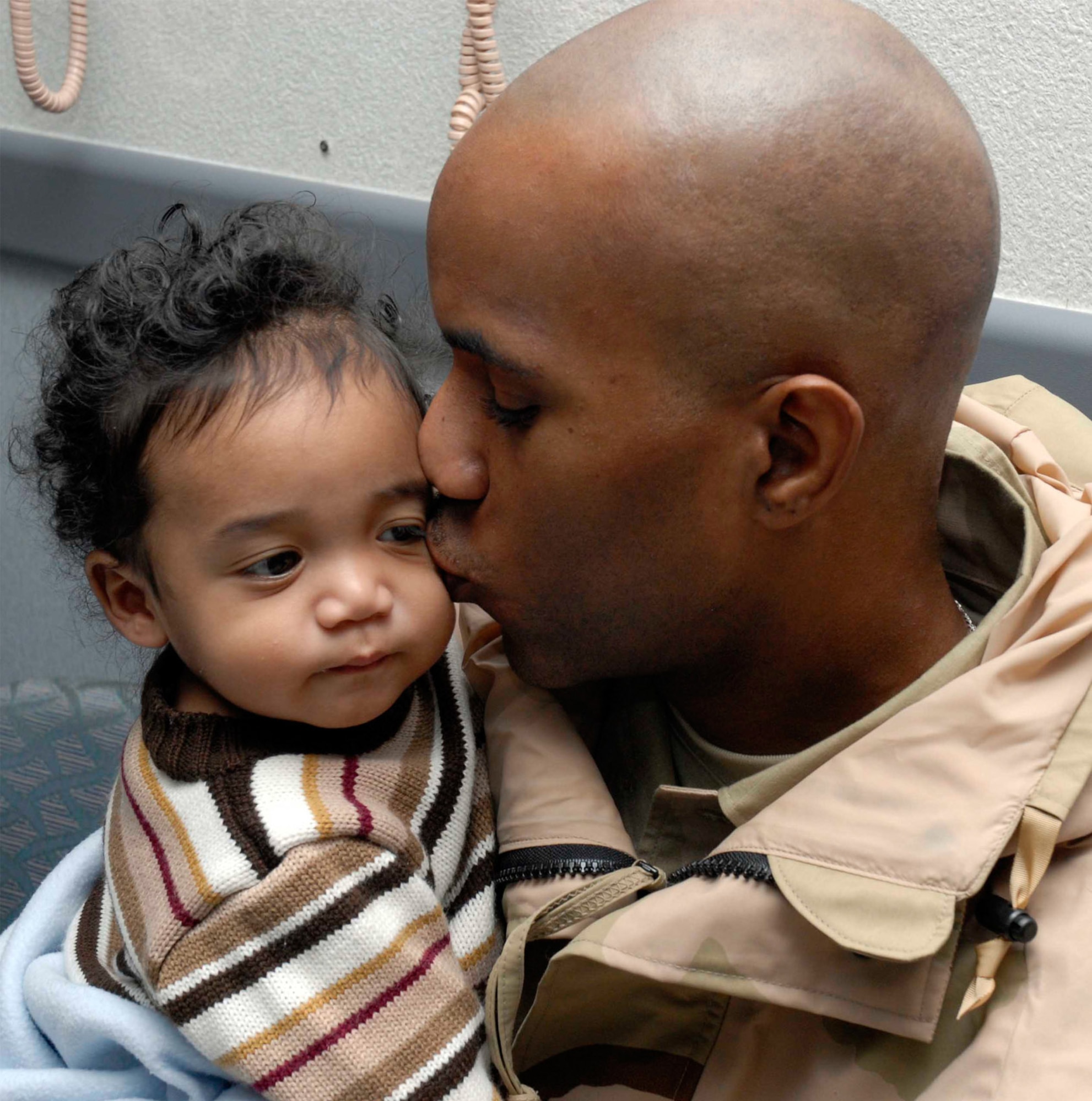 Senior Airman Brian Miles kisses his son, Brian, before his deployment recently.  Airman Miles' son is 10 months old.  Airman Miles is assigned to the 510th Expeditionary Fighter Squadron at Balad Air Base, Iraq.  He's deployed from the 18th Communications Squadron at Kadena AB, Japan. (Courtesy Photo)