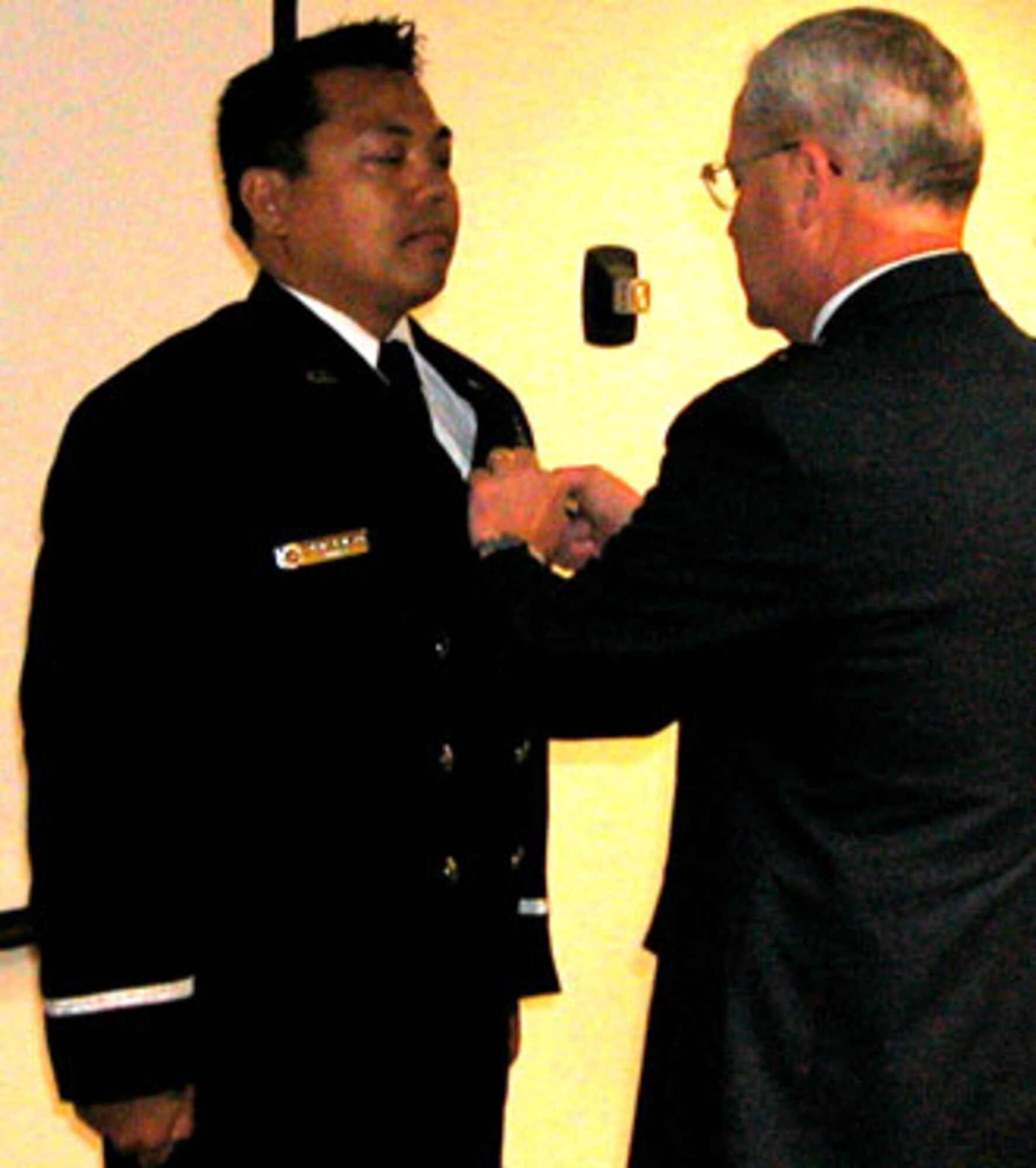 Mr. Roderick Rambayon, 452nd Air Mobility Wing Fire Department, March Air Reserve Base, is awarded the Air Force Civilian Achievement Medal and wing coin from Brig Gen James L. Melin, 452 AMW commander, for exceptional performance on March Brush Engine 10 during the Esperanza fire on 26 October 2006.  Five U.S. Forest Service firefighters died battling an arson wildfire where they were overcome by 90-foot-tall walls of flame advancing at 40 mph.
Mr. Rambayon provided medical treatment and sustained one of the firefighter’s, Pablo Cerda, life in an effort to get him to the hospital; he died five days later from burns to 90 percent of his body.  The five firefighters were trapped in a burnover which can occur when an advancing fire driven by high winds jumps a protective line and traps firefighters in its path. The trapped firefighters did not have time to don their protective gear.  (U.S. Air Force photos by LaGina Jackson)
