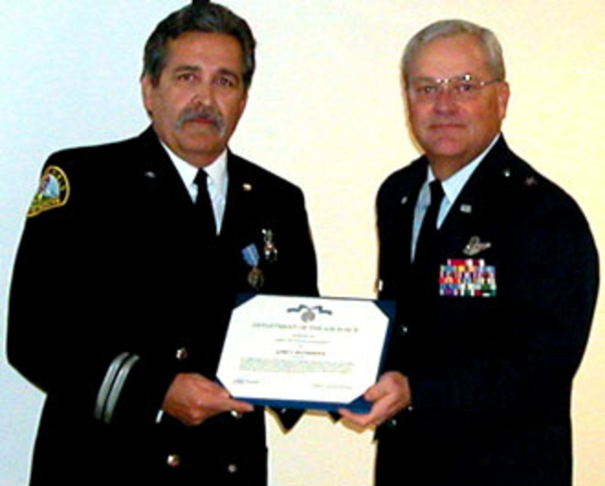 Mr. Gary Bicondova, 452nd Air Mobility Wing Fire Department, March Air Reserve Base, is awarded the Air Force Civilian Achievement Medal and wing coin from Brig Gen James L. Melin, 452 AMW commander, for exceptional performance on March Brush Engine 10 during the Esperanza fire on 26 October 2006.  Five U.S. Forest Service firefighters died battling an arson wildfire where they were overcome by 90-foot-tall walls of flame advancing at 40 mph.
Mr. Bicondova used his emergency medical technician skills to sustain the live of another firefighter, Captain Mark Loutzenhiser, who later died at the hospital from severe burns to his entire body. The five firefighters were trapped in a burnover which can occur when an advancing fire driven by high winds jumps a protective line and traps firefighters in its path. The trapped firefighters did not have time to don their protective gear.  (U.S. Air Force photos by LaGina Jackson)
