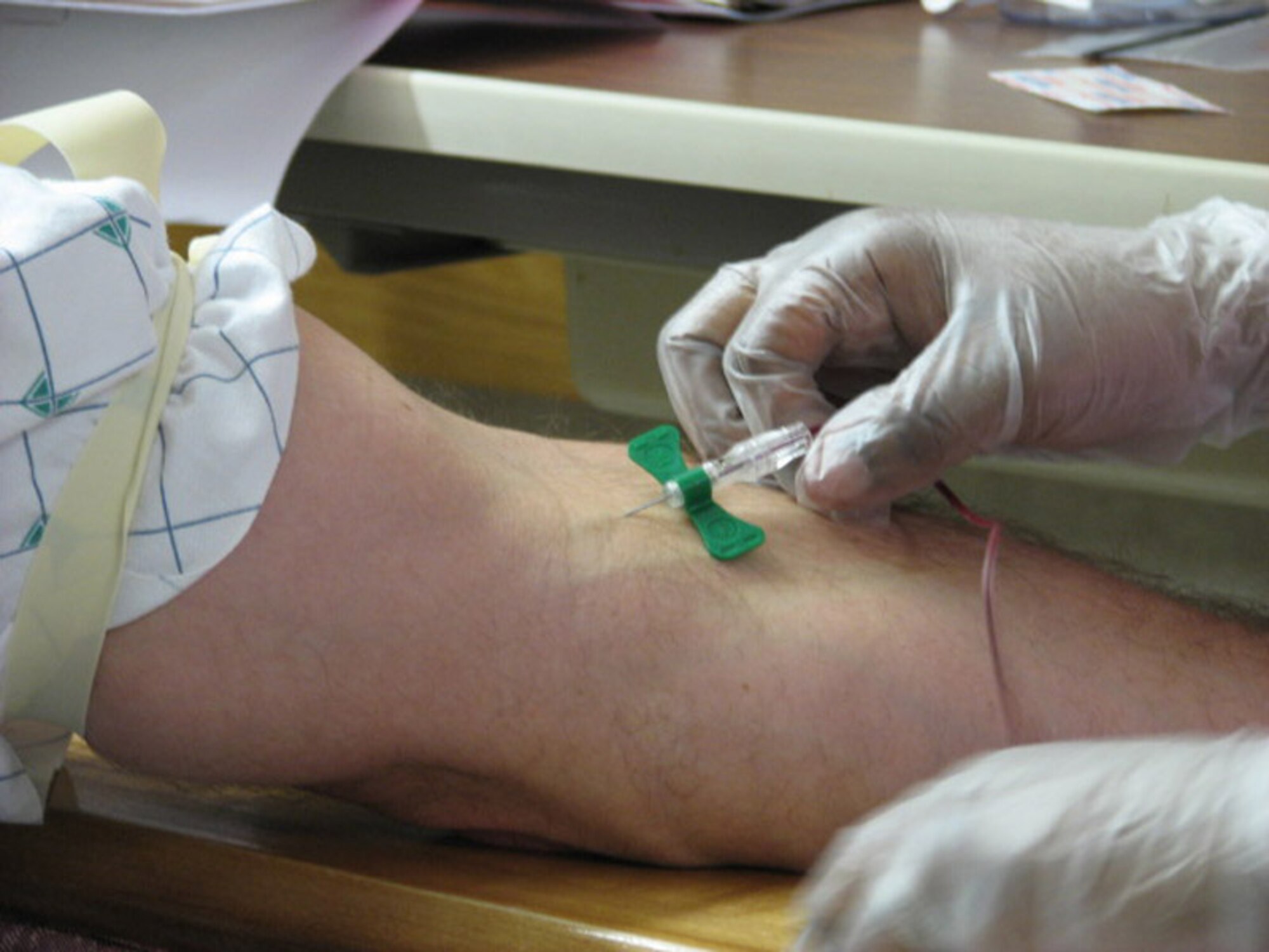 A staff member of the Georgetown University Hospital in Washington, D.C., draws blood from Master Sgt. Michael Castillo, 22nd Logistics Readiness Squadron, Jan. 3, at the hospital. Sergeant Castillo had his blood draw prior to undergoing surgery to donate bone marrow to a 10-month-old baby. (Air Force phot by Master Sgt. Francine Bish)