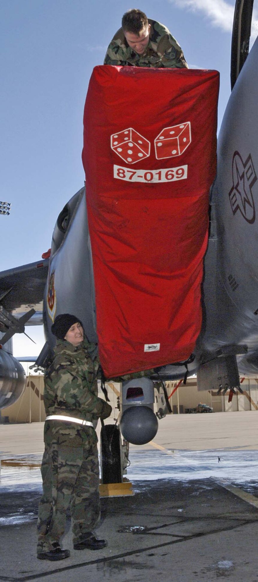 MOUNTAIN HOME AIR FORCE BASE, Idaho -- Staff Sgt. Eric Tautfest and Senior Airman Megan Paine, both from the 391st Aircraft Maintenance Unit, secure the engine intake covers on an F-15E Strike Eagle during the base’s Sharpshooter exercise here Feb. 26. The week-long exercise tested the 366th Fighter Wing’s ability to deploy to an overseas location to conduct combat operations from this austere location. Air Force photo by Airman 1st Class Ryan Crane