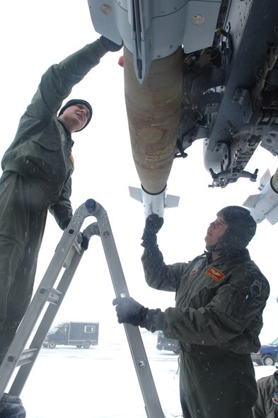 MINOT AIR FORCE BASE, N.D. -- First Lt. Justin Cox (left) and Capt. Dennis Cummings, both from the 23rd Bomb Squadron, inspect a laser guided bomb attached to a B-52H Stratofortress before a scheduled flight Feb. 28, 2007. Snow fall accumulation delayed the flight until March. 1. The crew will fly to the Marine Corps Air Ground Combat Center 29 Palms, Calif. to test the missile. (U.S. Air Force photo by Senior Airman Christopher Boitz)