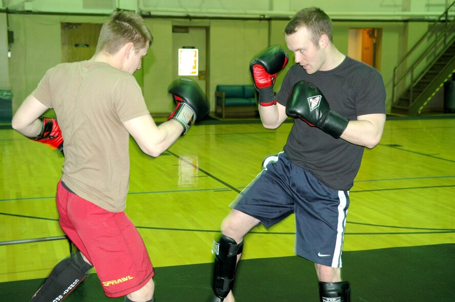 FAIRCHILD AIR FORCE BASE, Wash. -- Airmen 1st Class Eddie Fore(left) and Jacob Chambers, Survival, Evasion, Resistance and Escape specialists, take part Wednesday in a leg kick-high kick partner drill that practices the technique of how to take a low kick and cover up to block a high kick. The two airmen attend a Mixed Martial Arts class that meets three times each week at the SERE gym. (Photo by Staff Sgt. Larry Carpenter)
