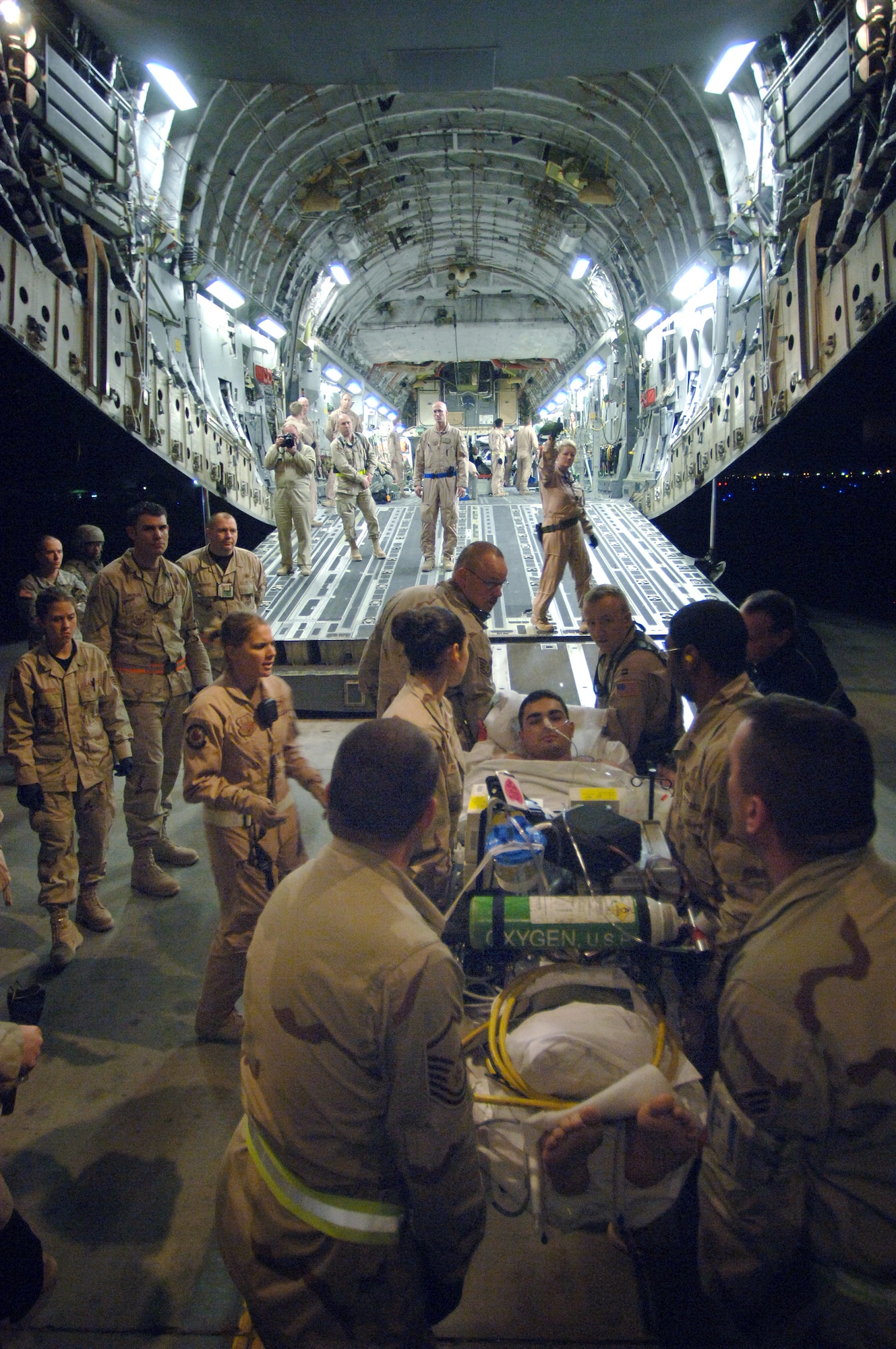 Airmen from the 332nd Medical Group Contingency Aeromedical Staging Facility and volunteers from all over the 332nd Air Expeditionary Wing load injured military members onto a C-17 Globemaster III Feb. 21 departing from Balad Air Base, Iraq, to Landstuhl, Germany, where they will receive further care for their wounds. The Contingency Aeromedical Staging Facility is a staging where patients are prepared for their flight out of Iraq. (U. S. Air Force photo/Staff Sgt. Michael R. Holzworth)