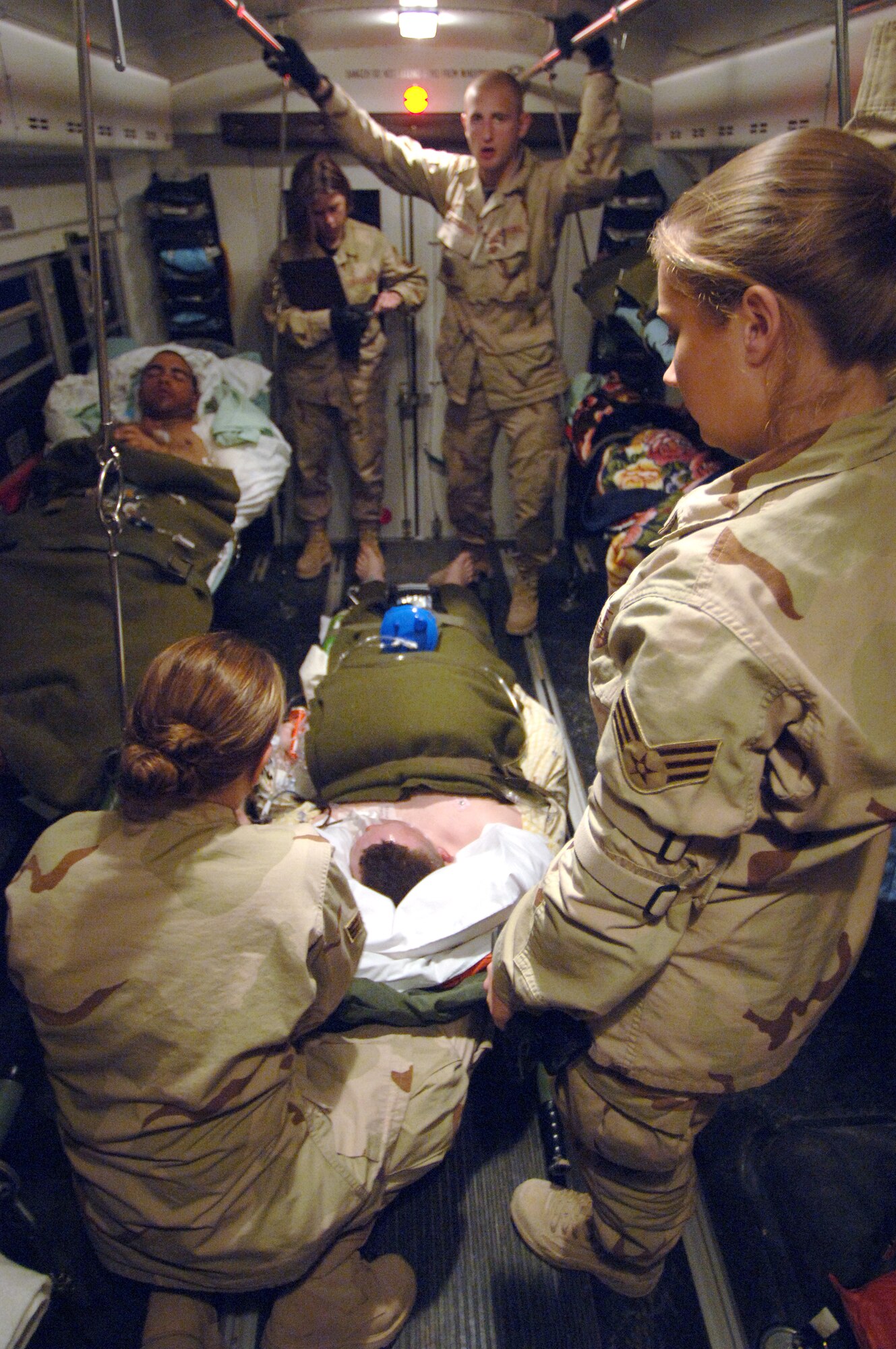 Senior Airman Deana Stefko, Senior Airman Tara Gensler, Senior Airman Travis Mortenson, and Staff Sgt. Katie Hagemeier care for injured patients on the medical transport bus while in route to a C-17 Globemaster III departing Feb. 21 from Balad Air Base, Iraq, to Landstuhl, Germany, where they will receive further care for their wounds. The Airmen are assigned to the 332nd Medical Group Contingency Aeromedical Staging Facility. (U. S. Air Force photo/Staff Sgt. Michael R. Holzworth)